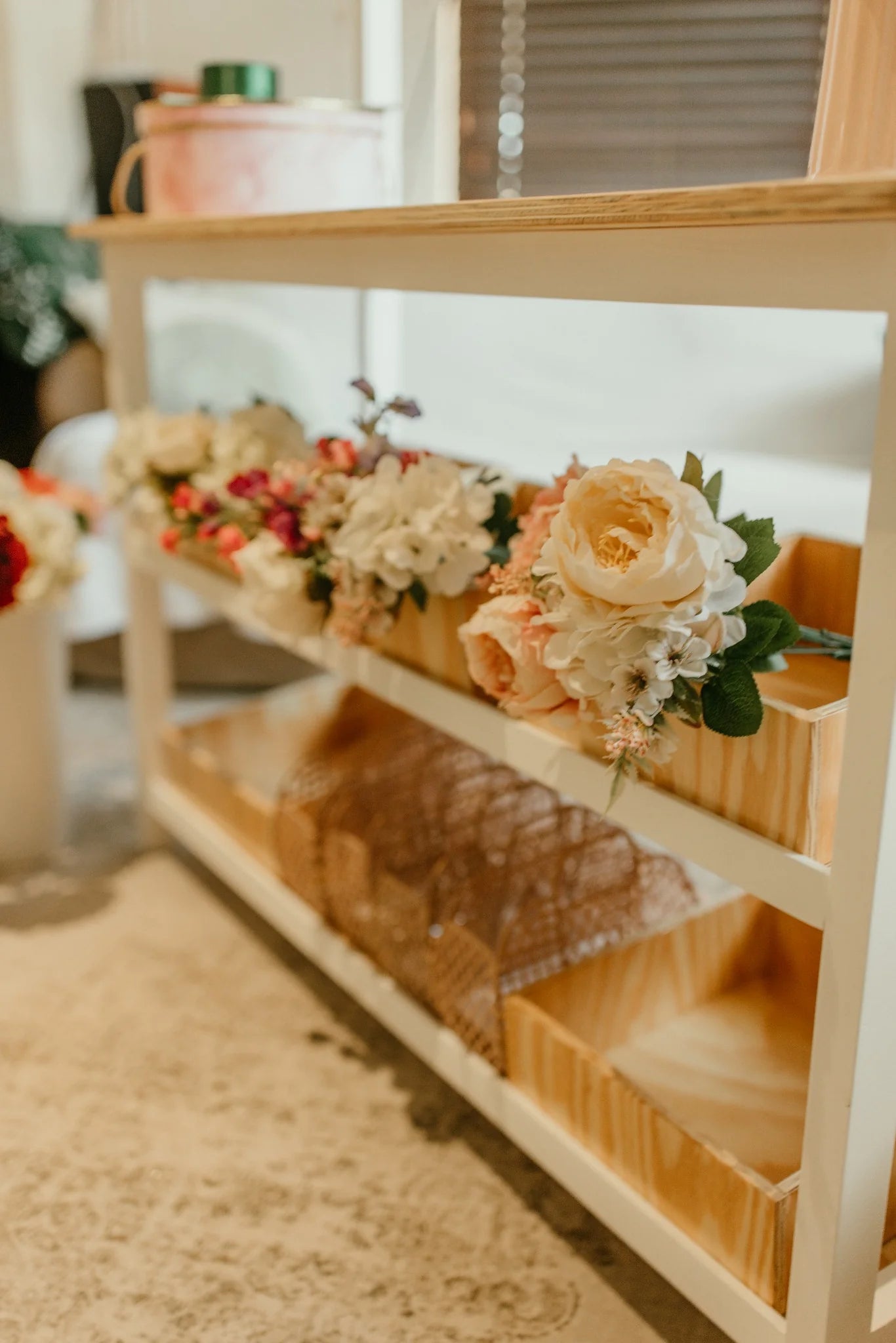 lose-up of wooden storage bins on the kids play shop styled with flower props.