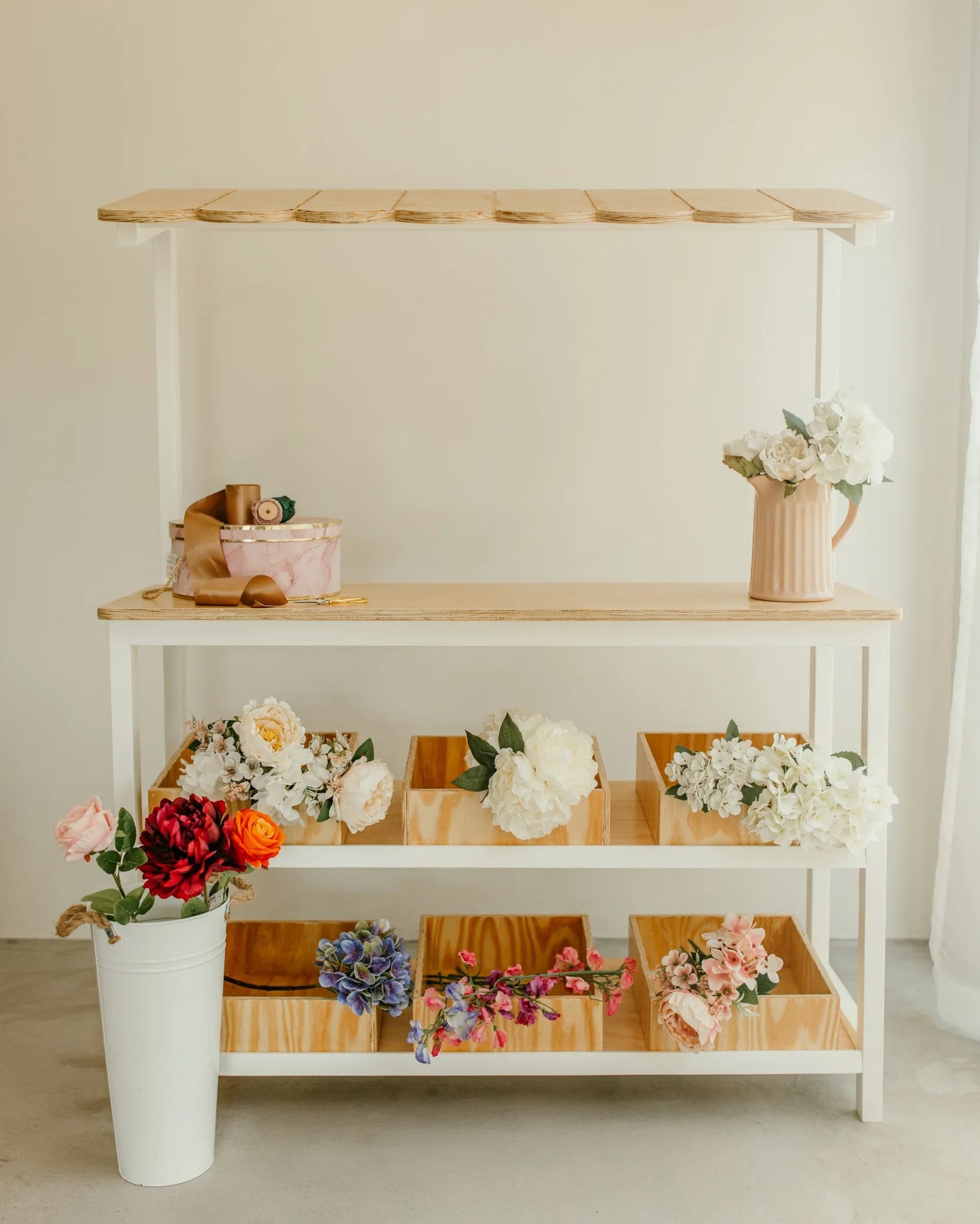 Kids wooden play shop styled as a flower stand, full front view with canopy and bins.