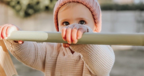 Little girl climbing on her Montessori inspired Pikler Playground