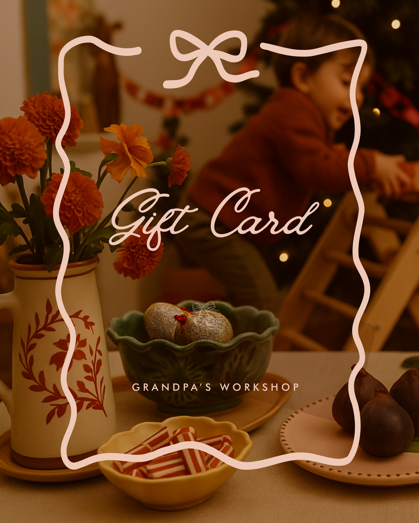 Christmas-themed gift card design featuring festive ceramics, flowers and ornaments on a table, with a child playing near a Christmas tree in the background. Text on the image reads ‘Gift Card – Grandpa’s Workshop.