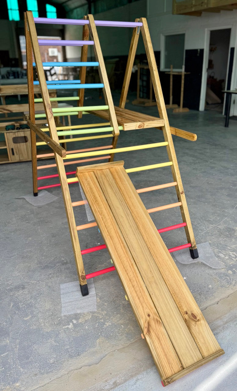 Reversible ramp and slide attached to the Outdoor Pikler Playground, shown with the smooth slide side facing up on the treated-timber structure.