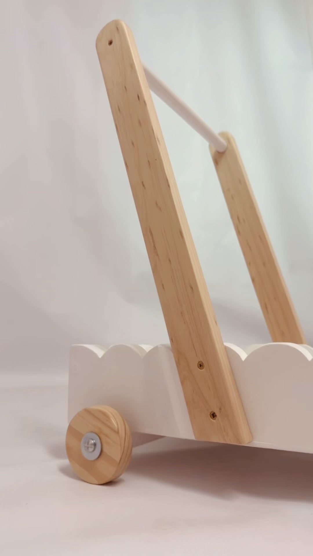 Load and play video in Gallery viewer, Scalloped wooden baby walker in motion showing smooth rolling wheels and scalloped edge design for first steps
