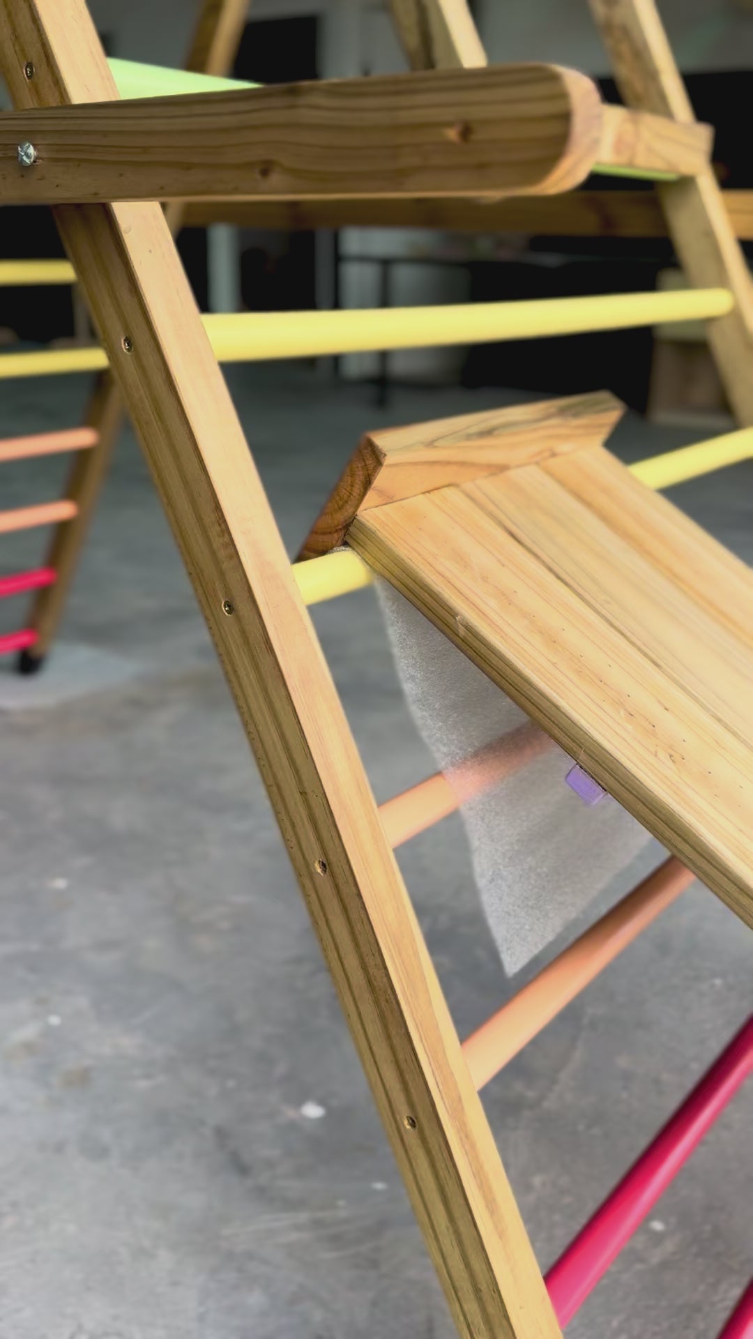 Load and play video in Gallery viewer, Close-up video of the reversible ramp and slide on the Outdoor Pikler Playground, showing the smooth slide side attaching securely to the treated-timber climbing frame.
